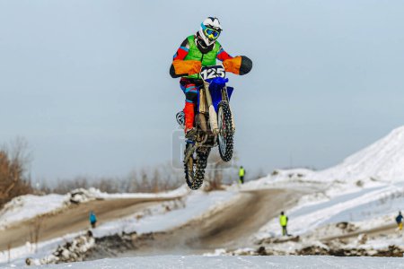 Téléchargez les photos : Motocross cavalier sautant sur tremplin neigeux, hiver hors route course de moto - en image libre de droit