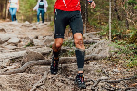 Foto de Corredor masculino correr maratón sendero forestal en medias artesanales y zapatillas de correr Solomon - Imagen libre de derechos