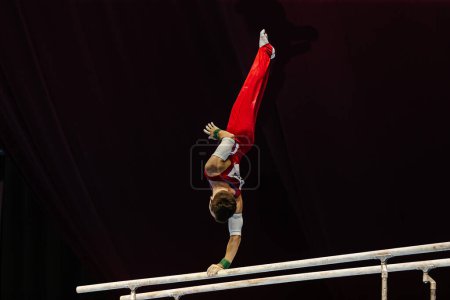 Photo for Gymnast exercise on parallel bars competition artistic gymnastics, summer sports games - Royalty Free Image