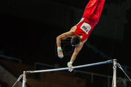 Foto de Atleta gimnasta ejercicio en barra horizontal competición gimnasia artística, juegos de deportes de verano - Imagen libre de derechos