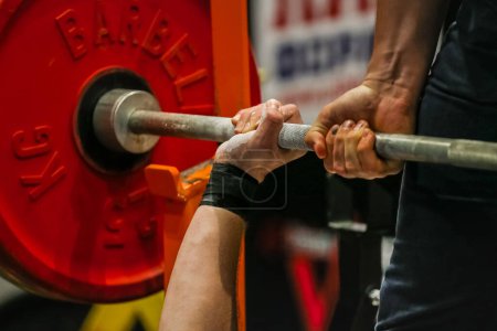 Photo for Arm powerlifter in wrist wraps to hold heavy barbell before bench press powerlifting competition - Royalty Free Image