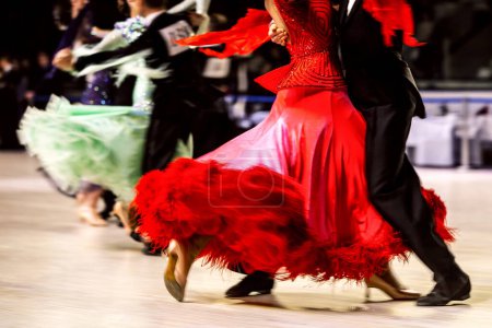 Photo for Dance couple dancing waltz in competitive ballroom dancesport, woman is wearing red dress and black tail suit on man - Royalty Free Image