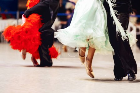 Foto de Parejas bailando vals vienés en competitivos bailesport de salón, la mujer está usando vestido púrpura y rojo, el hombre en traje de cola negro - Imagen libre de derechos