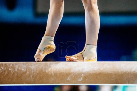 Foto de Primer plano piernas gimnasta femenina paso en la viga de equilibrio en la gimnasia, soporte de tobillo de neopreno equipado con la taza del talón - Imagen libre de derechos