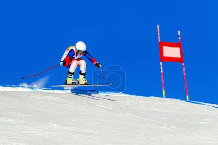 Photo for Female racer on alpine skiing track, snowy slope on blue sky background, winter sports games - Royalty Free Image