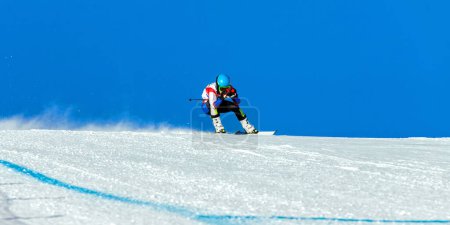 Photo for Male ski racer on alpine skiing track downhill, snowy slope on blue sky background, winter sports games - Royalty Free Image