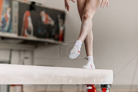 Photo for Legs female gymnast step on balance beam in artistic gymnastics, sports summer games - Royalty Free Image