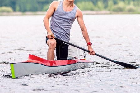 Foto de Vista frontal atleta macho piragüista en canoa solo, después de la línea de meta, remar el agua, deportes al aire libre de verano - Imagen libre de derechos