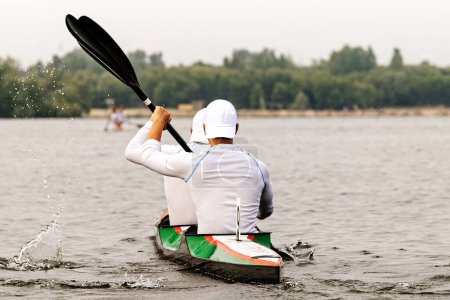 Photo for Rear view two male kayakers on kayak double in kayaking competition race, sports summer games - Royalty Free Image