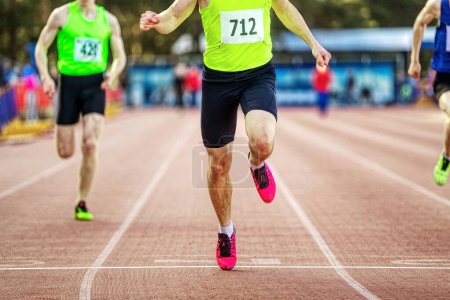 Photo for Male athlete runner crosses finish line sprint race in athletics championships, close-up man sprinter winner of competition - Royalty Free Image