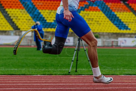 Photo for Male runner para-athlete on Nike prosthesis and spikes shoes running track stadium, summer para athletics championships - Royalty Free Image