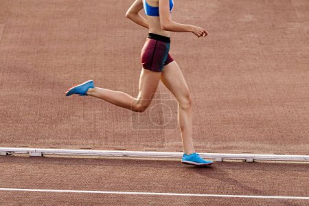 Foto de Delgada joven corredor de media distancia corriendo en el estadio en campeonatos de atletismo de verano - Imagen libre de derechos