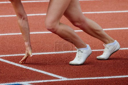 Photo for Female athlete runner starting position run sprint race red track stadium, summer athletics championships - Royalty Free Image