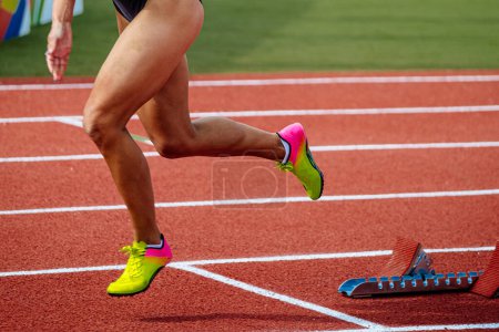 Photo for Legs female runner starting running in sprint race red track stadium, summer athletics championships - Royalty Free Image