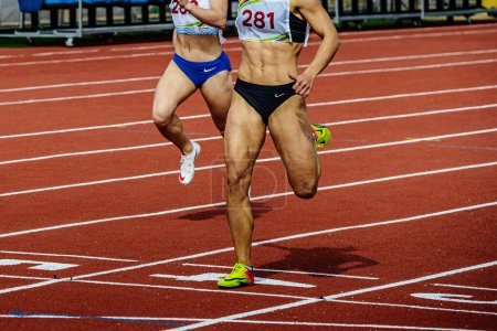 Foto de Atleta femenina carrera final pista estadio, campeonatos de atletismo de verano, Nike marca corriendo zapatos de espigas y pantalones cortos - Imagen libre de derechos