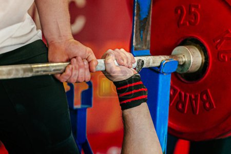 Photo for Hand male powerlifter holding barbell in bench press, coach provides support powerlifting competition - Royalty Free Image