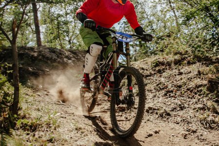 Téléchargez les photos : Cycliste cycliste masculin chevauchant piste poussiéreuse descente course en forêt, championnat d'été de VTT - en image libre de droit