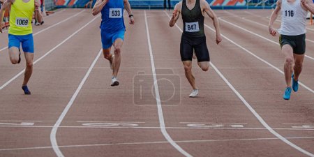 Foto de Cuatro corredores de atletas masculinos corriendo carrera de sprint, se ejecutan en la línea de meta, campeonatos de atletismo de verano - Imagen libre de derechos
