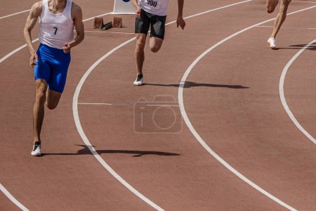 Photo for Three male athlete runners starting running sprint race, summer athletics championships - Royalty Free Image