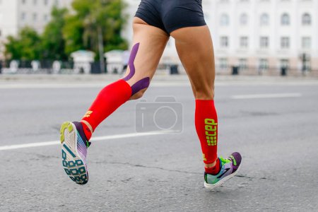 Téléchargez les photos : Chaussures de course Brooks et chaussettes de compression CEP, marathon de course de coureuses jambes en ville, course de sports d'été - en image libre de droit