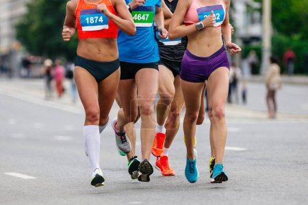 Foto de Vista frontal pequeño grupo femenino corredores atletas corriendo maratón en la ciudad, carrera deportiva de verano - Imagen libre de derechos