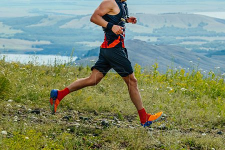 Foto de Corredor masculino corriendo carrera de senderos maratón en el fondo de las montañas y el lago, ultramaratón de verano - Imagen libre de derechos