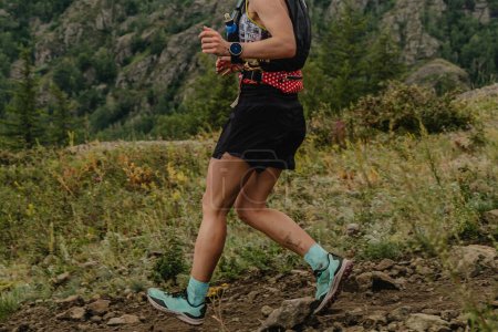Photo for Female runner running down mountain, summer trail marathon race - Royalty Free Image