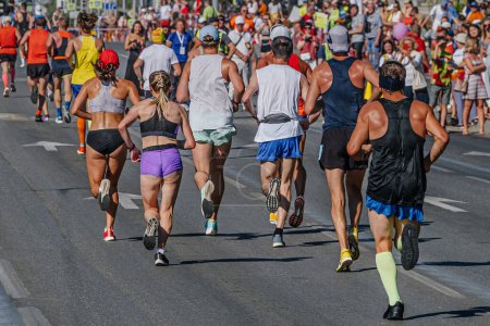Téléchargez les photos : Arrière groupe coureurs athlètes femmes et hommes courir marathon de la ville, fans de bord de route regarder les athlètes - en image libre de droit