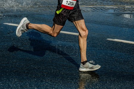 Téléchargez les photos : Jambes coureur masculin course marathon dans la flaque d'eau, sports d'été jeux - en image libre de droit