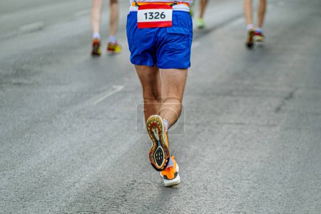 Rückansicht Laufsohle Laufschuhe männlicher Läufer laufen Marathonlauf in grauem Asphalt