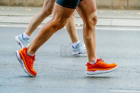 Foto de Close-up piernas pareja corredores hombre y mujer corriendo maratón carrera juntos - Imagen libre de derechos