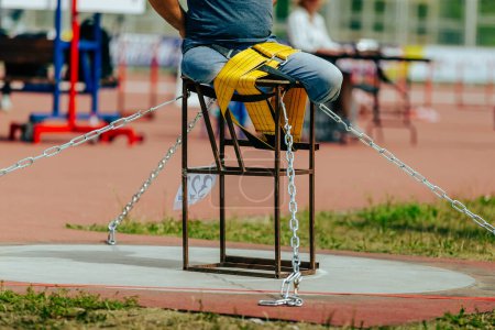 Photo for Athlete without legs tied to table with belt shot put in para athletics, summer sports games - Royalty Free Image