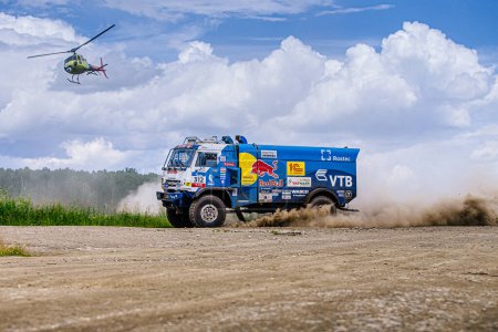 Foto de Región de Chelyabinsk, Rusia - 10 de julio de 2017: Kamaz cross-country truck c escort helicopter during rally "Silk Way" - Imagen libre de derechos