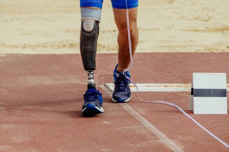 Photo for Athlete disability measures run-up in long jump at athletics competition, sports summer games - Royalty Free Image