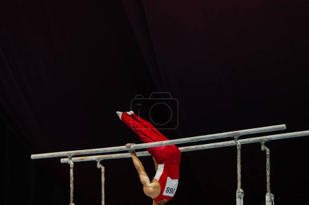 Foto de Gimnasta ejercicio barras paralelas en la gimnasia campeonato, elemento zhou shixioug - Imagen libre de derechos