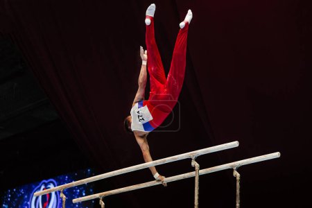 Foto de Gimnasta ejercicio barras paralelas en el campeonato de gimnasia - Imagen libre de derechos