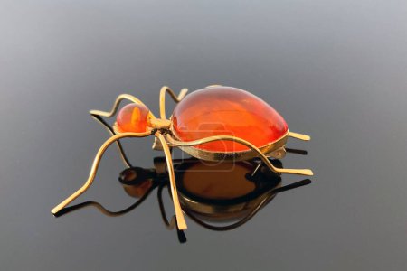 Photo for Vintage brooch "Ant" with of amber and brass, made in USSR on dark glossy background - Royalty Free Image