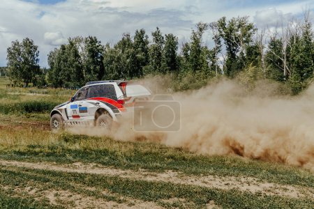Téléchargez les photos : Vue arrière voiture de course se déplaçant sur la route de terrain en rallye de cross country - en image libre de droit