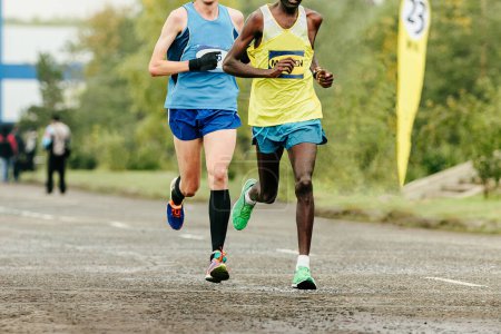Téléchargez les photos : Deux coureurs course marathon, vue de face, vêtus de vêtements de sport lumineux - en image libre de droit