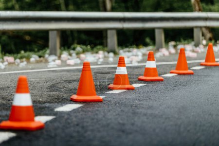 Photo for Six orange traffic cones standing in row on mountain road - Royalty Free Image