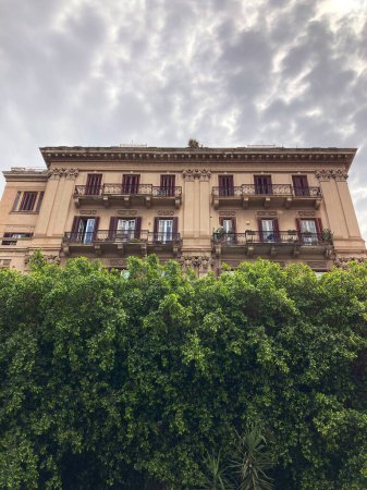 antigua casa en Palermo en el fondo del cielo y árboles verdes