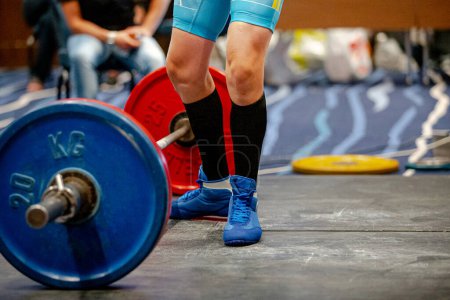 Foto de Piernas mujer atleta en calcetines de rodilla negro cerca de barbell deadlift - Imagen libre de derechos