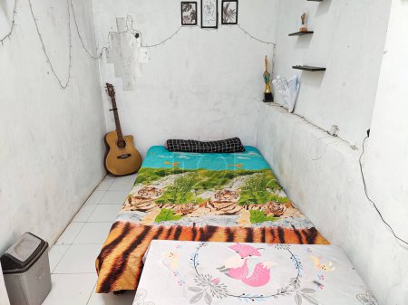 Téléchargez les photos : Klaten, Indonesia - December 2022 : neat and clean room atmosphere. a bed to lie down to unwind in the house. real life. white floor and white walls. - en image libre de droit