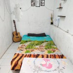 Klaten, Indonesia - December 2022 : neat and clean room atmosphere. a bed to lie down to unwind in the house. real life. white floor and white walls.