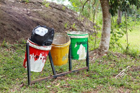 Téléchargez les photos : Yogyakarta, Indonésie - 01 janvier 2023 : jeter les ordures dans les poubelles selon la couleur. vert pour les déchets organiques, jaune pour les déchets inorganiques et rouge pour les déchets B3 ou les matières toxiques et dangereuses. - en image libre de droit
