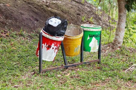 Téléchargez les photos : Yogyakarta, Indonésie - 01 janvier 2023 : jeter les ordures dans les poubelles selon la couleur. vert pour les déchets organiques, jaune pour les déchets inorganiques et rouge pour les déchets B3 ou les matières toxiques et dangereuses. - en image libre de droit