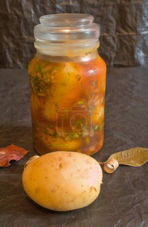 patatas crudas mezcladas con varios condimentos de cocina para encurtidos, maceradas para su conservación