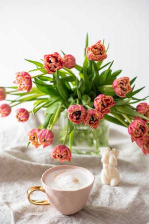 Téléchargez les photos : Cup with cappuccino, spring flowers tulips, morning concept, soy candle, woman's day - en image libre de droit