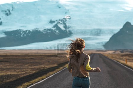Téléchargez les photos : Road on Iceland, glacier, blond woman running, amazing view - en image libre de droit