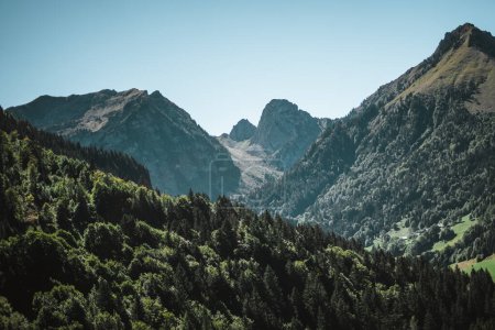 Foto de Majestuosas montañas en los Alpes cubiertas de árboles y nubes - Imagen libre de derechos